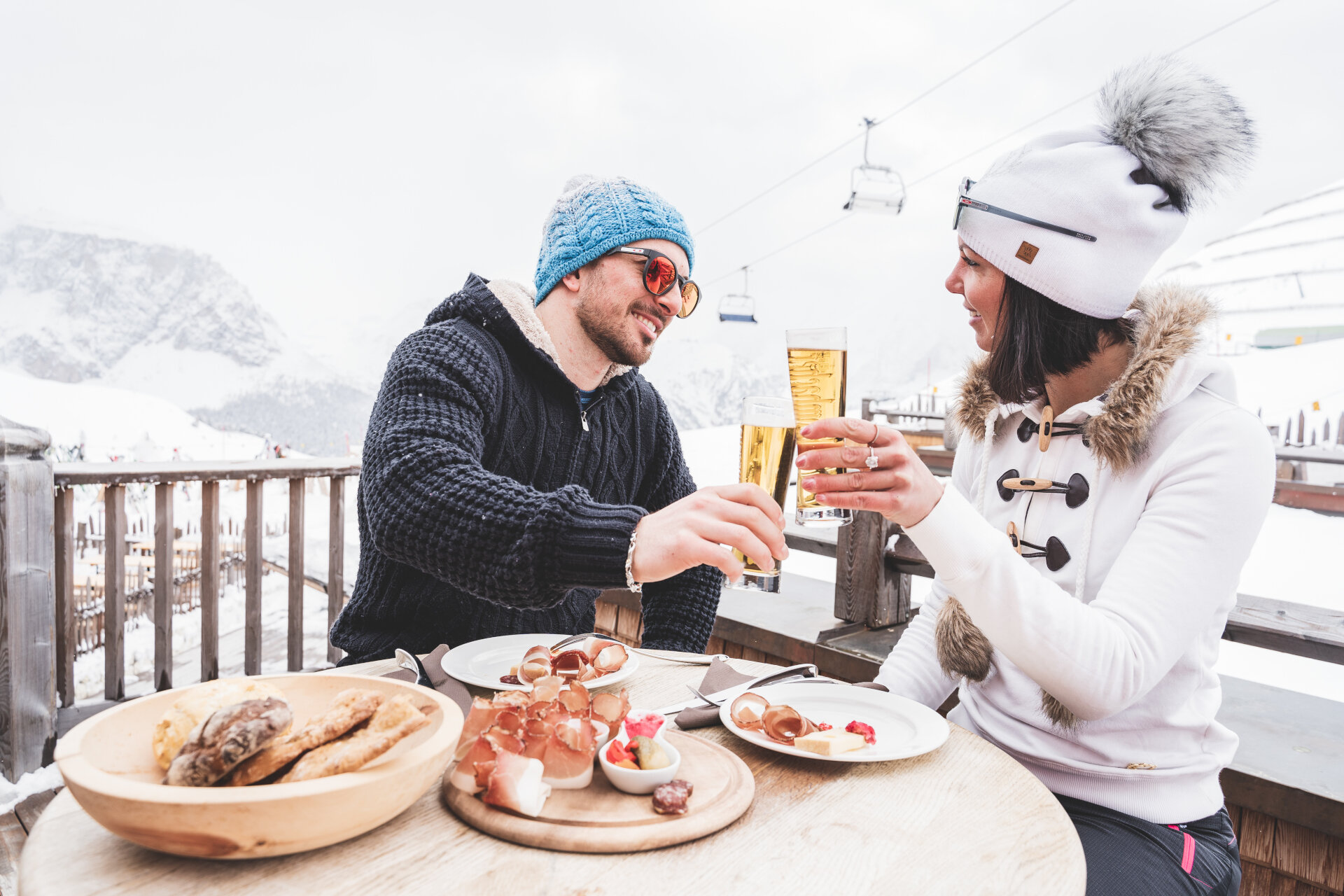 Coppia fa un brindisi durante un aperitivo in rifugio ad alta quota in inverno | © Patricia Ramirez  - Archivio Immagini ApT Val di Fassa