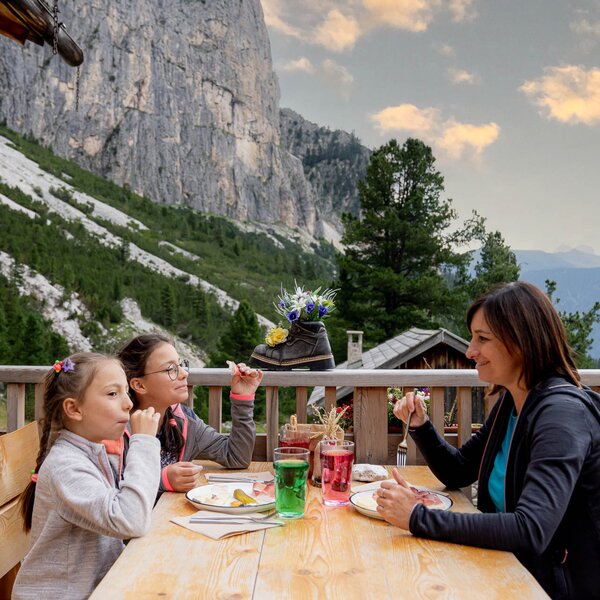 Famiglia che mangia fuori da una malga sulle Dolomiti in Val di Fassa | © Mattia Rizzi - Archivio Immagini ApT Val di Fassa